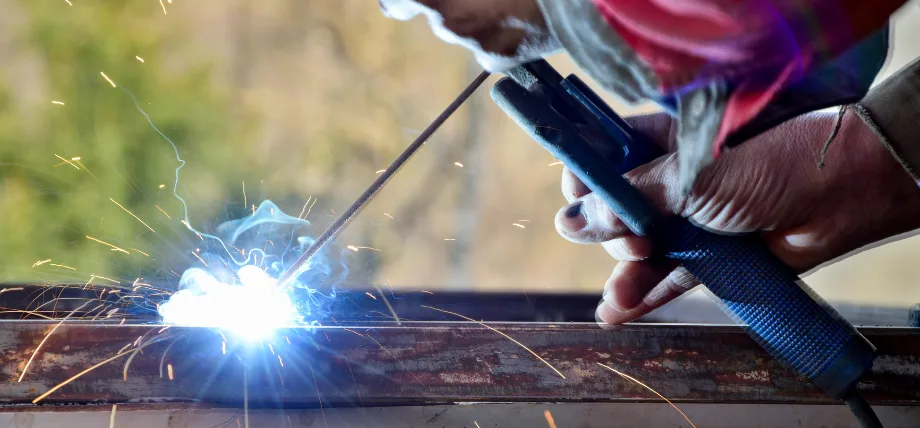 welding sparc on a rusty steel piece with hand