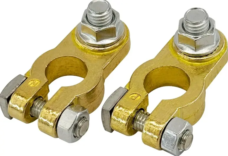 Two yellow brass car battery terminals, each equipped with a matching silvery bolt and screw assembly for clamping