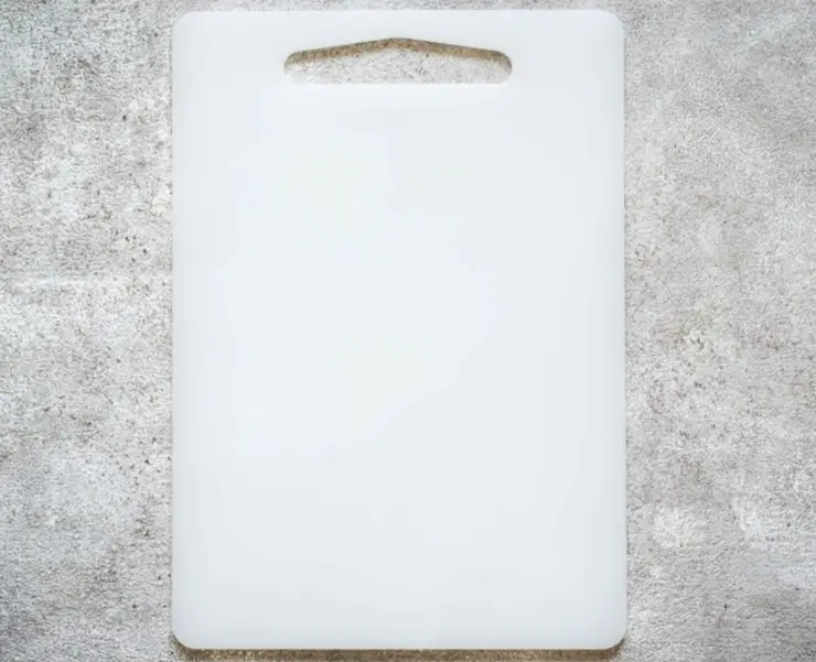 White acetal cutting board with handle showing low moisture absorption properties