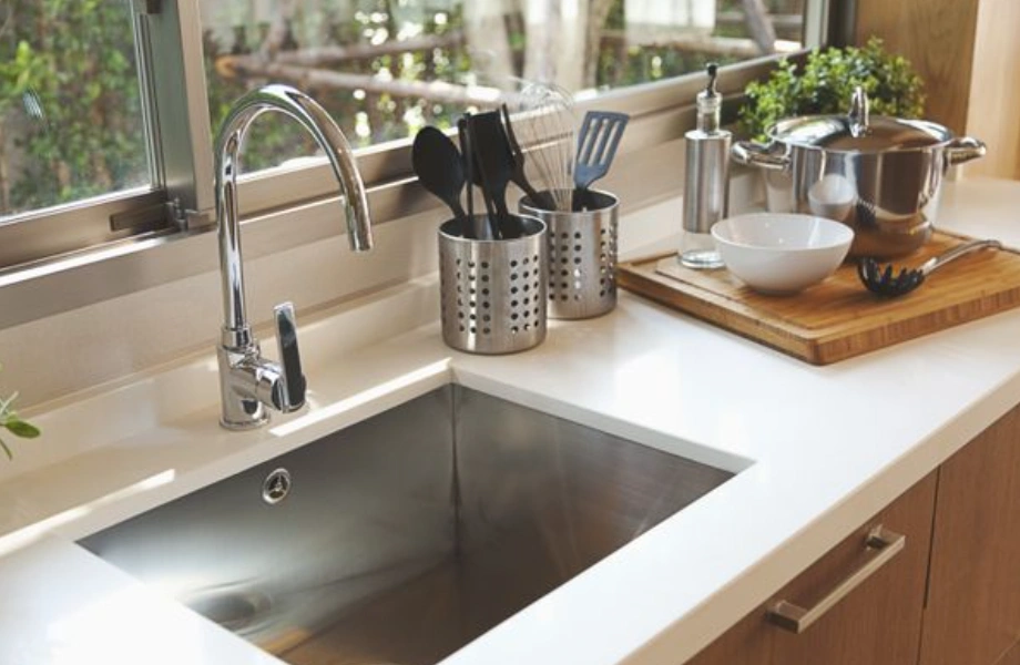 White amino resin thermoset kitchen made of thermosetting material, countertop with undermount stainless steel sink and wooden cutting board