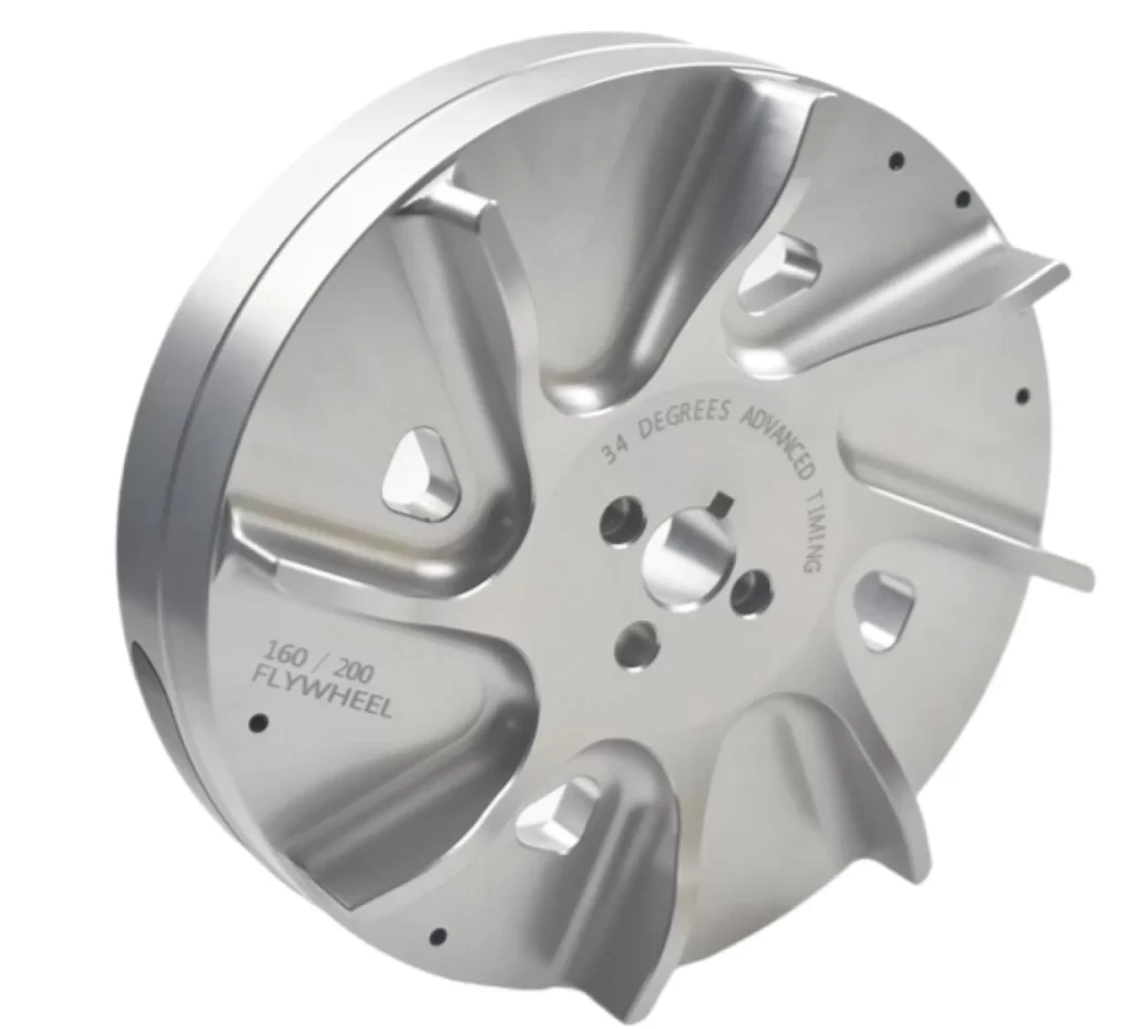 A polished billet flywheel with precision CNC-machined fins, a bore, and mounting holes