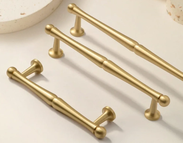 Three contoured brass cabinet pulls with gold finish
