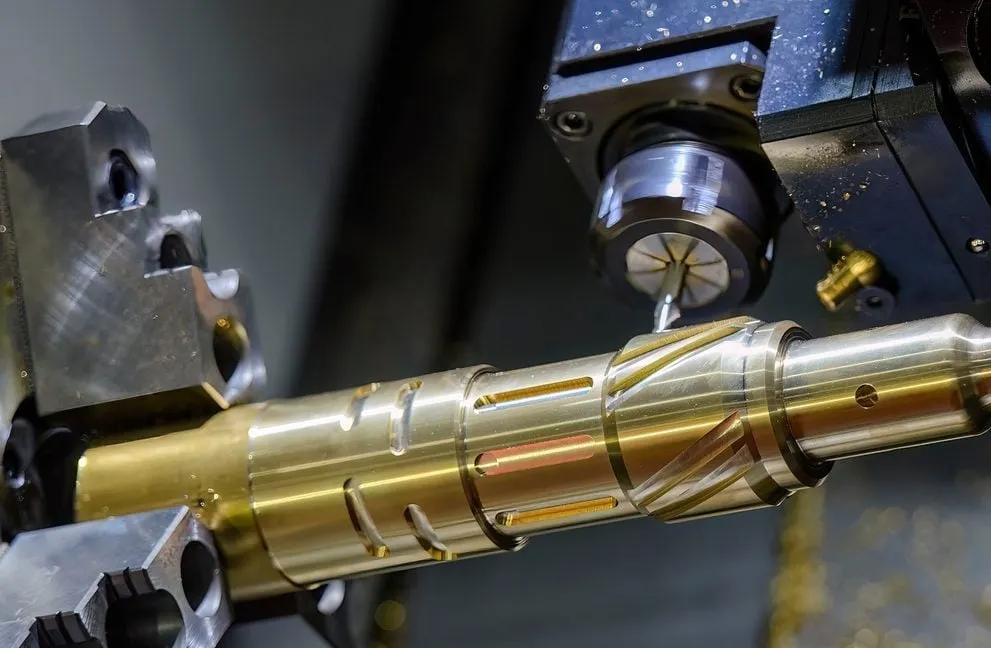CNC machine turning brass shaft with precision grooves and threading during the manufacturing process