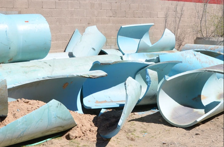 Fragments of blue plastic pipes after brittle failure