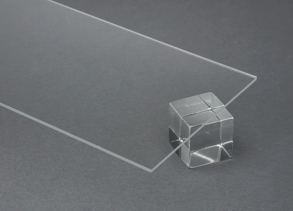 Clear cast acrylic sheet with a cube block demonstrating superior optical clarity