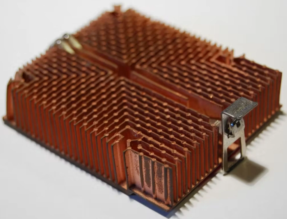 A closeup of a golden heat sink used for thermal management in aerospace electronics