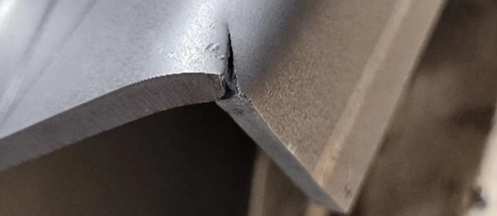 Close-up of joggle joint crack showing material failure at a bend