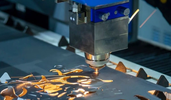 An image of a compact-looking machine showing a fibre laser cutter creating intricate shapes on a metal sheet