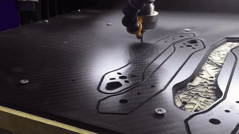 Laser cutting shapes in a carbon fiber sheet.