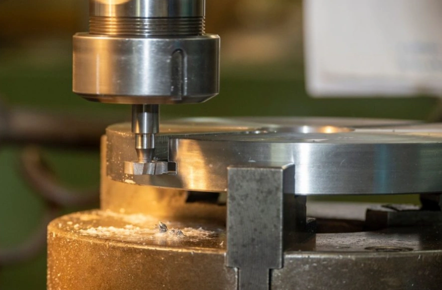 A close-up picture of a plain side milling cutter machining the edge of a metallic disc