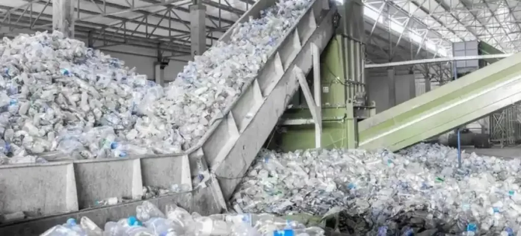 Industrial plastic bottle recycling facility with conveyor belts sorting plastic containers for reprocessing