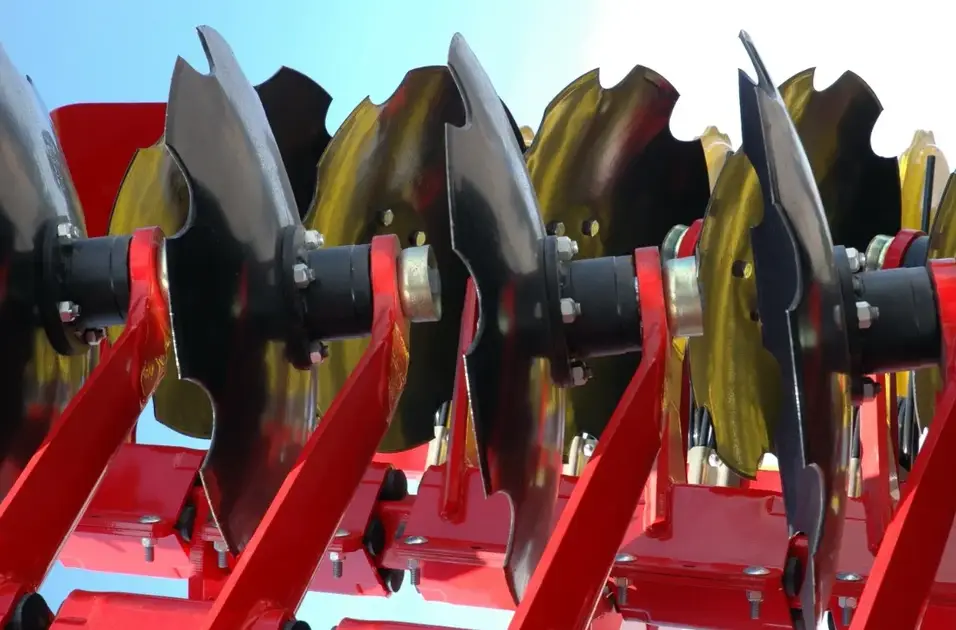 A closeup of four black C-type rotary blades and red supports