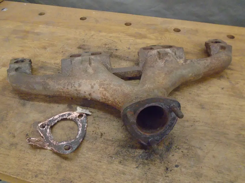 A closeup image of an exhaust manifold covered in rust