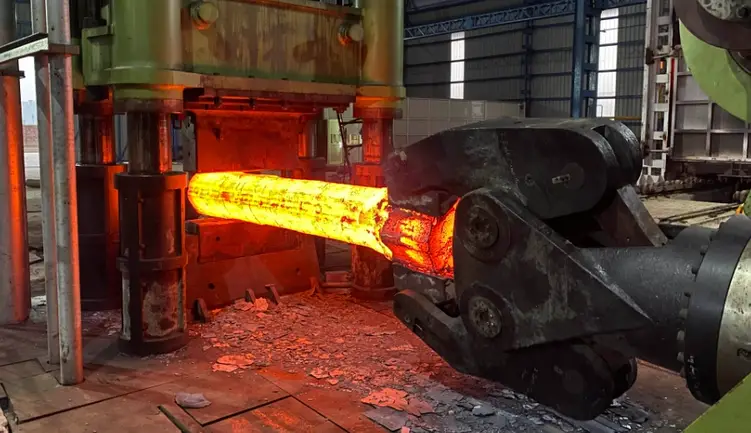 Red-hot metal shaft being shaped through the forging process