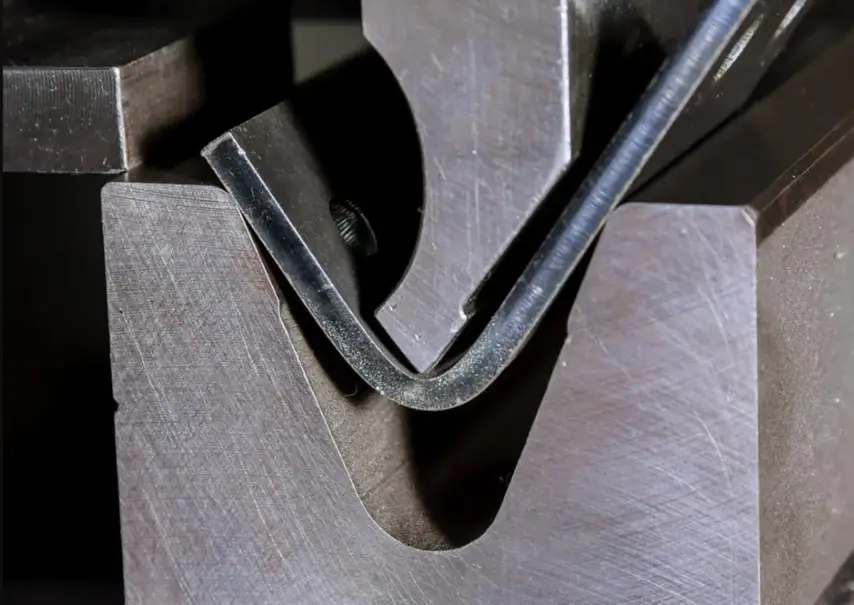 A close-up of sheet metal bending using a press brake
