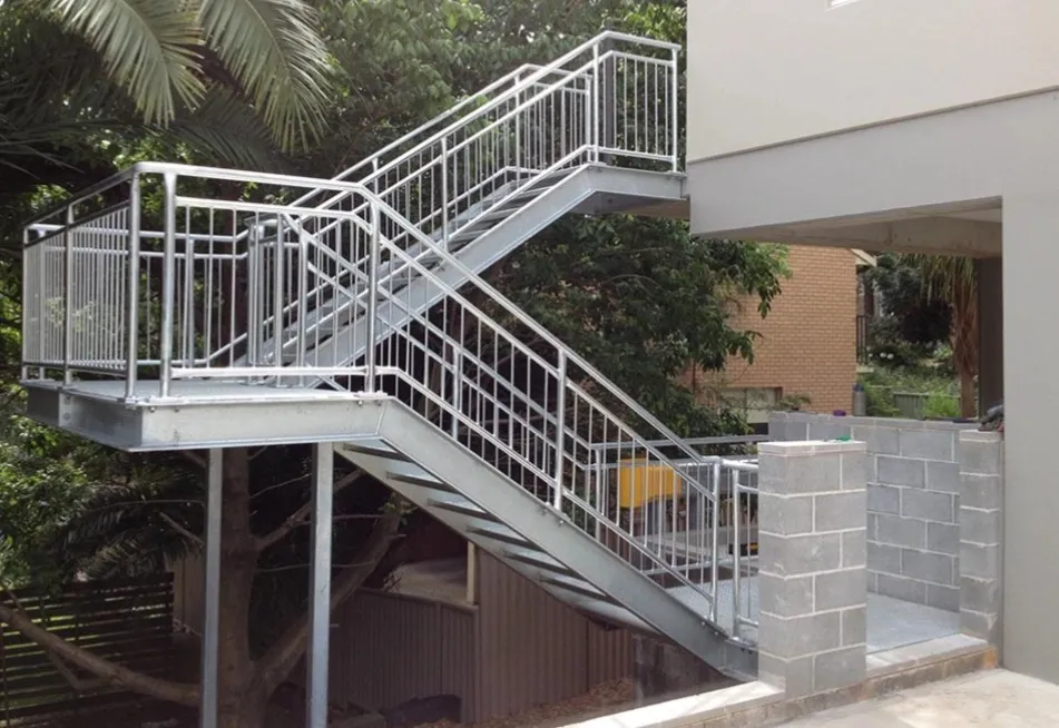 A section of a building and 1018 steel handrails connecting from the ground floor to 1st floor