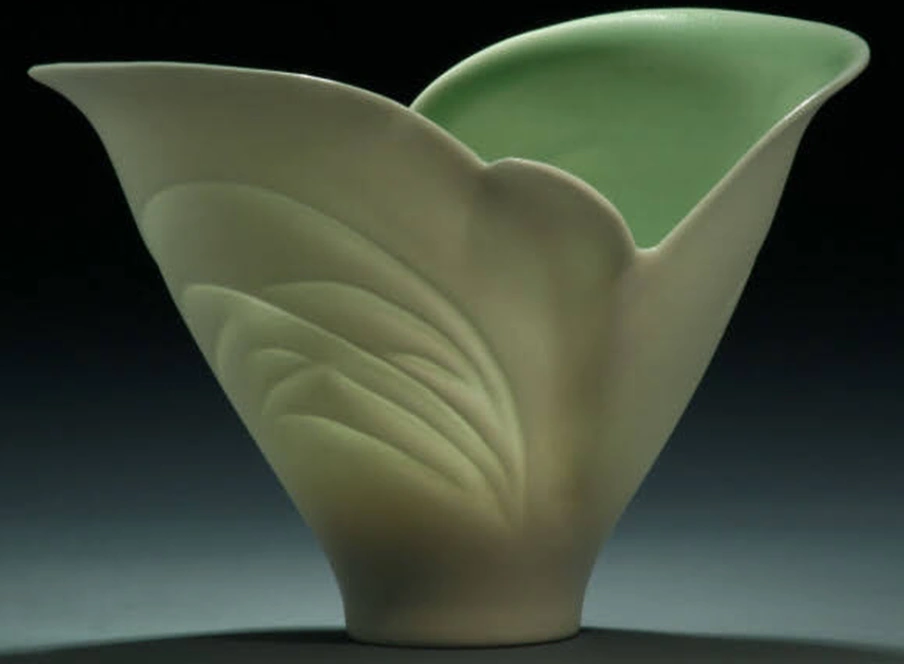 A closeup image of a light green vase-like artwork of translucent ceramic